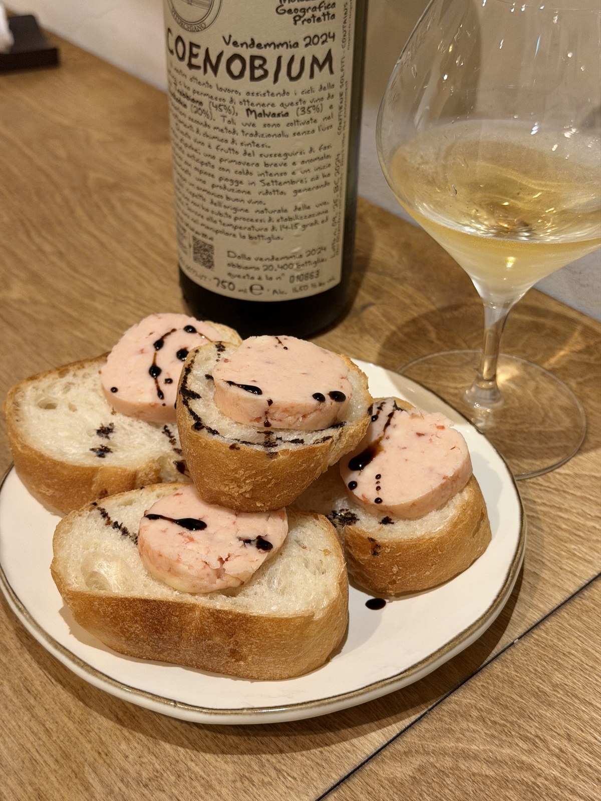 ピンク色のバターをのせたバゲットと白ワイン
